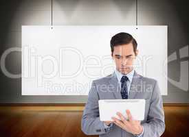 Composite image of businessman holding a tablet computer