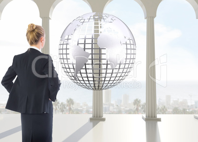 Composite image of businesswoman standing with hands on hips