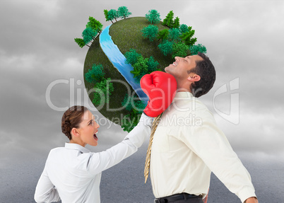 Composite image of businesswoman hitting a businessman with boxi