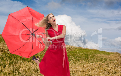 Composite image of elegant blonde holding umbrella