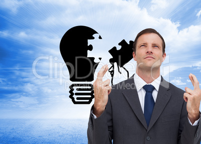 Composite image of serious businessman with fingers crossed is l