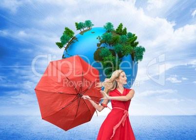 Composite image of elegant blonde holding umbrella