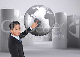 Composite image of serious asian businessman pointing