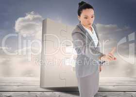 Composite image of unsmiling asian businesswoman pointing