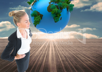 Composite image of businesswoman standing with hands on hips