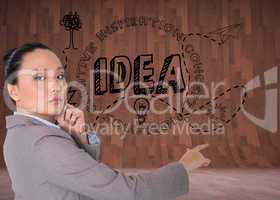 Composite image of thoughtful asian businesswoman pointing