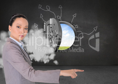 Composite image of unsmiling asian businesswoman pointing