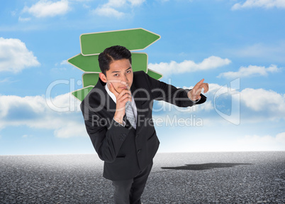 Composite image of thoughtful asian businessman pointing