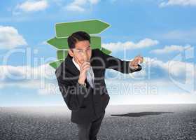 Composite image of thoughtful asian businessman pointing