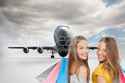 Composite image of two young women with shopping bags