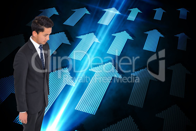 Composite image of stern businessman looking down