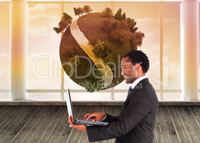 Composite image of businessman working on laptop