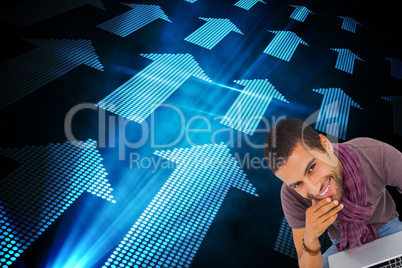 Composite image of thoughtful man sitting on floor using laptop