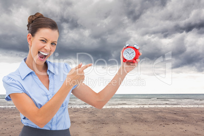 Composite image of businesswoman indicating alarm clock