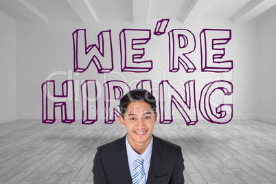 Smiling businessman standing in front of were hiring graphic