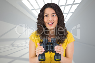 Composite image of smiling casual young woman holding binoculars