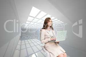 Composite image of smiling businesswoman sitting and using lapto