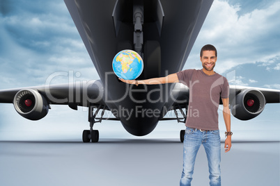 Composite image of handsome man holding out a globe