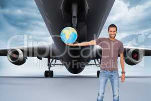 Composite image of handsome man holding out a globe