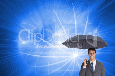 Composite image of happy businessman holding grey umbrella