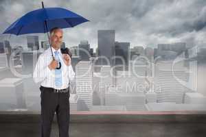 Composite image of happy businessman holding umbrella