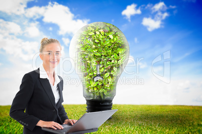 Composite image of businesswoman using laptop