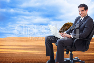 Composite image of young businessman sitting on an armchair work