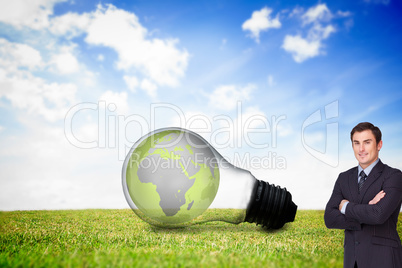 Composite image of young businessman standing cross-armed