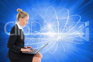 Composite image of businesswoman using laptop