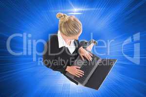 Composite image of businesswoman using laptop