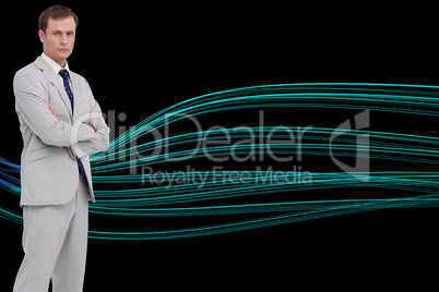 Composite image of serious businessman standing with his arms fo