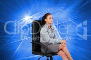 Composite image of portrait of a serious businesswoman sitting o