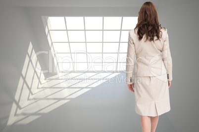 Composite image of classy businesswoman walking away from camera