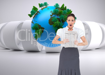 Composite image of shocked stylish businesswoman holding newspap
