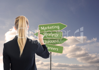 Composite image of business woman pointing somewhere