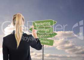 Composite image of business woman pointing somewhere