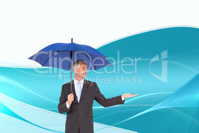 Composite image of happy businessman holding umbrella