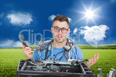 Composite image of confused it professional with cables and phon