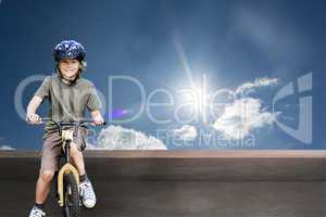 Composite image of little boy with his bike in a park