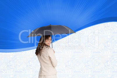 Composite image of rear view of classy businesswoman holding umb