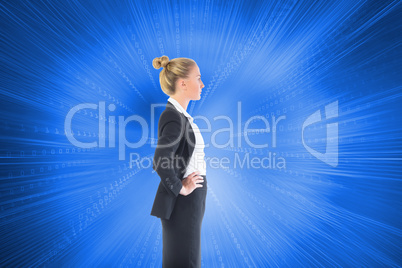 Composite image of businesswoman standing with hands on hips