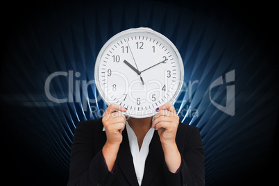 Composite image of businesswoman in suit holding a clock