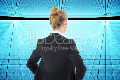 Composite image of businesswoman standing with hands on hips