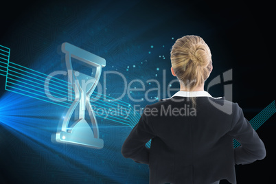 Composite image of businesswoman standing with hands on hips