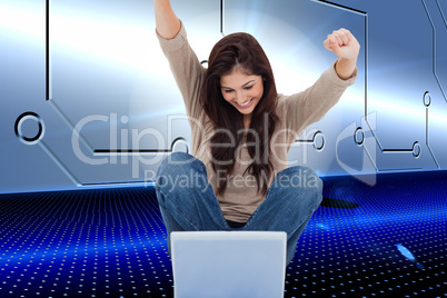 Composite image of brunette cheering while using laptop