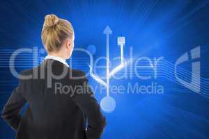 Composite image of businesswoman standing with hands on hips