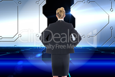 Composite image of businesswoman standing with hands on hips