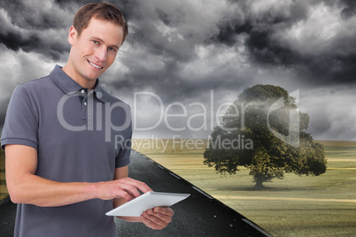 Composite image of smiling young man with tablet computer