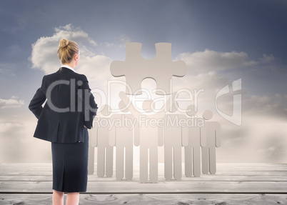 Composite image of businesswoman standing with hands on hips