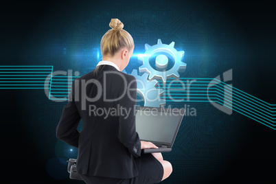 Composite image of businesswoman using laptop